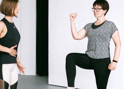 Two women working out together, demonstrating fitness exercises on a white background.